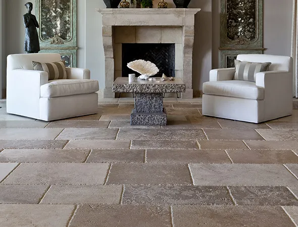A beautifully renovated living room displays a marble floor, a comfortable couch, and an elegant lamp, enhancing the space.