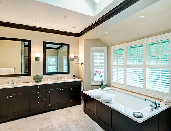 A beautifully renovated bathroom with a large tile floor and a sleek tub, highlighting a blend of style and practicality.
