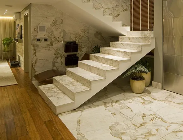 A beautifully renovated staircase featuring elegant marble walls and a polished wooden floor, showcasing modern design elements.