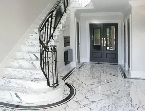 Elegant marble staircase in a home, featuring striking black and white marble floors, showcasing a recent renovation.