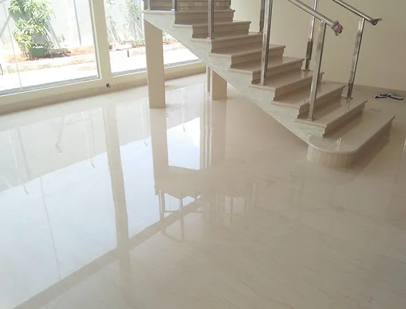 A beautifully designed marble staircase in a residence, complemented by white marble flooring, highlighting a renovation.