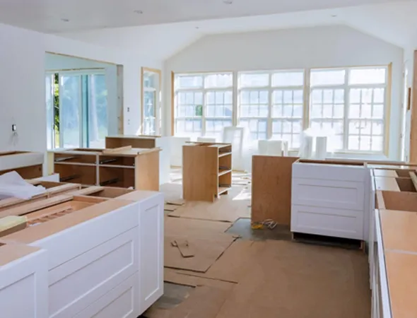 A kitchen under renovation, showcasing new cabinets and countertops being installed, highlighting the transformation process.